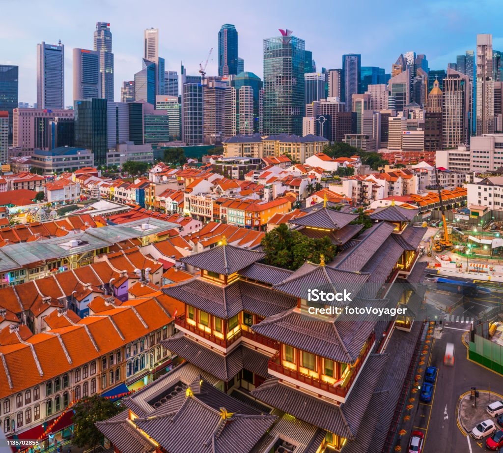 Singapore sunset Chinatown temples shops skyscraper cityscape aerial view The crowded skyscraper cityscape of the Downtown Core overlooking the warmly illuminated Buddha Tooth Relic Temple in Chinatown, Singapore. Aerial View Stock Photo