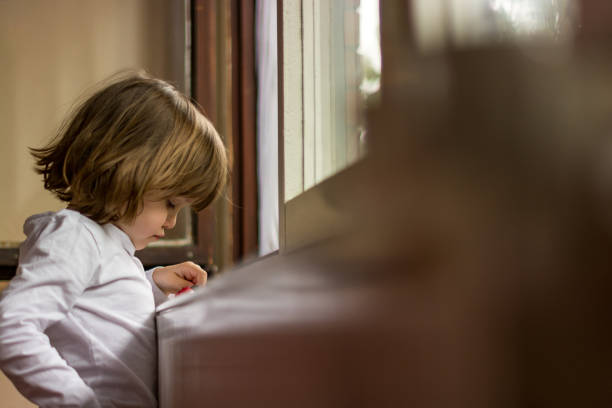 istock A sad little girl standing by the window 1135703004