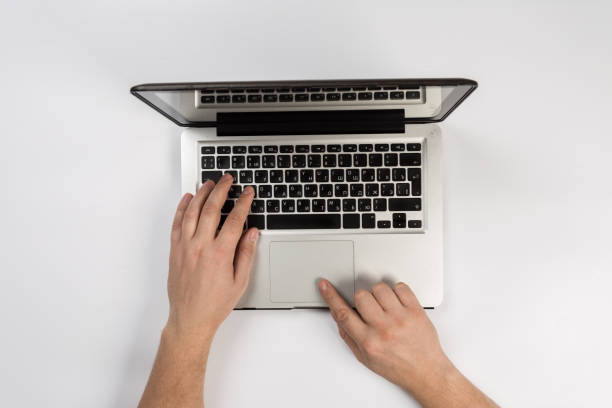 Male hands working on modern laptop. Office desktop on white background