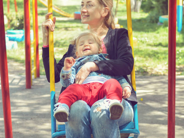 istock Mother swings on a swing with her small daughter 1135707739