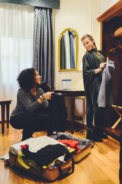 istock Friends unpacking clothes in hotel room 1135709512