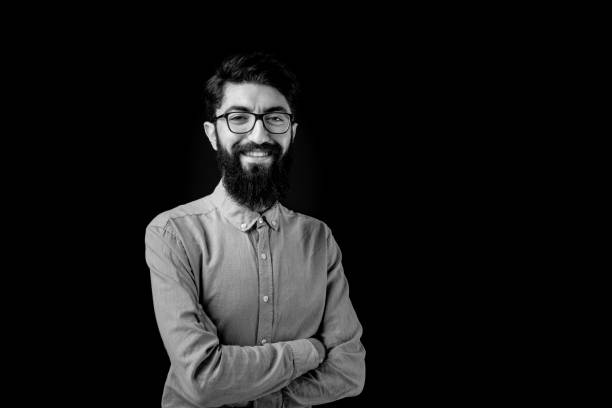 Young Bearded Man Portrait Black and white portrait of young bearded man with eyeglasses. black and white men facial hair beard stock pictures, royalty-free photos & images