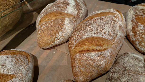 istock Baked rustic organic loaf bread on the counter in the bakery. 1135712170