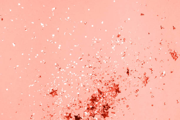 istock Living coral Christmas confetti and sparkles background. 1135713400