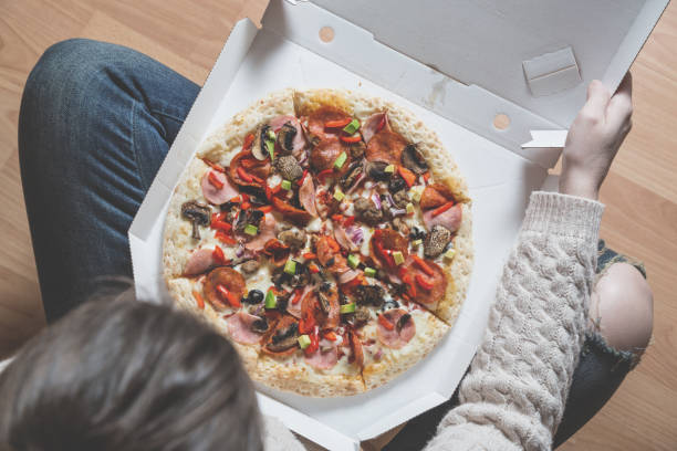 istock Girl holding pizza box 1135713960