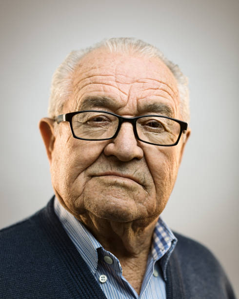 Portrait of real caucasian senior man with attitude Close up portrait of senior caucasian man with attitude against gray white background. Vertical shot of spanish real people staring in studio with white hair and glasses. Photography from a DSLR camera. Sharp focus on eyes. 90 plus years photos stock pictures, royalty-free photos & images