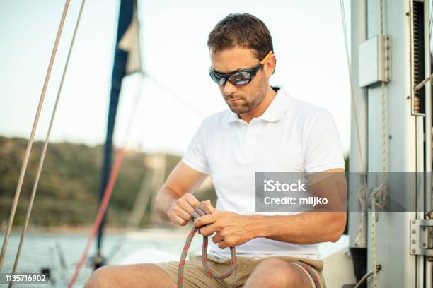 Skipper Of The Sailboat Stock Photo - Download Image Now - Tying, Tied Knot, Sail