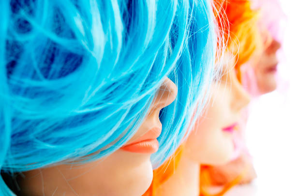 closeup of some wigs of different colors on mannequin heads