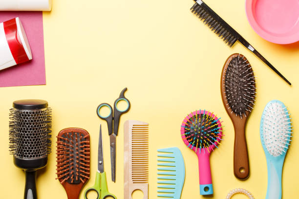 istock Picture of combs and scissors isolated on yellow background. 1135718301
