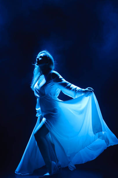 istock Actress / singer on stage in the rays of blue light. 1135728417