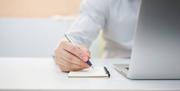 istock close up young journalist man hand use pen writing on notebook for lecture and make mind-mapping about data information and remind to do list , copywriter millennial lifestyle concept 1135729684