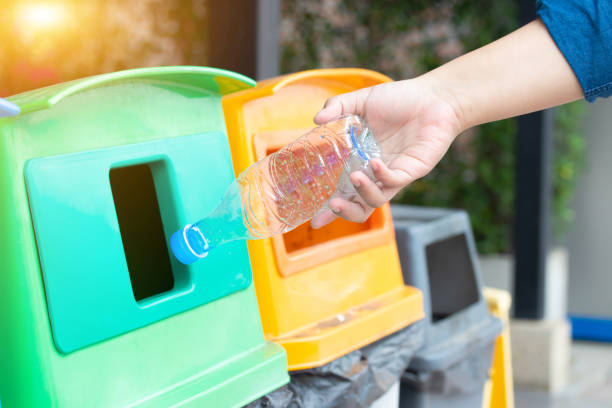 istock Closeup woman hand throwing empty plastic water bottle into the trash. Recycle bin. 1135733206