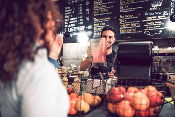 istock Smiling Waiter Tells Customer That The Smoothie Is Ready 1135733254