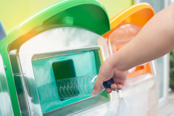 istock Closeup man hand throwing empty plastic water bottle into the trash. Recycle bin. 1135733397