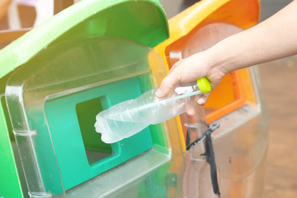 istock Closeup man hand throwing empty plastic water bottle into the trash. Recycle bin. 1135733448