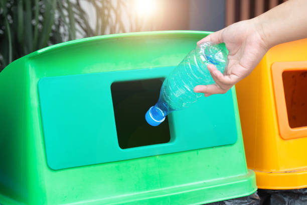 istock Closeup woman hand throwing empty plastic water bottle into the trash. Recycle bin. 1135733813
