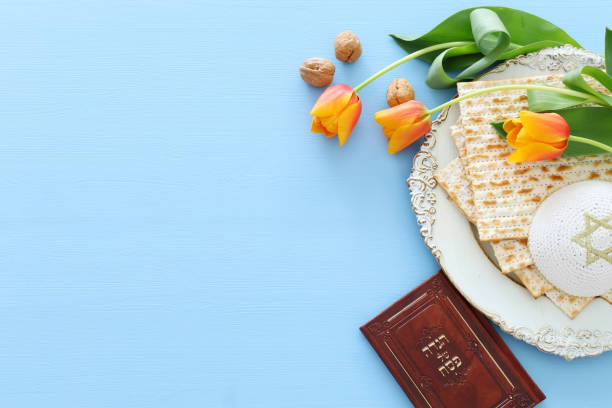 pesah のお祝いの概念 (ユダヤ人過越の休日)。ヘブライ語のテキストと伝統的な本: 過越のハッガーダー (過越の物語) - passover seder matzo table ストックフォトと画像