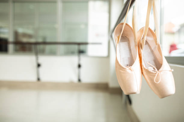 Ballet shoes hanging on a barre in a ballet studio, close up