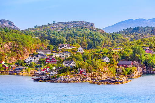 Norwegian scandinavian village landscape with fjord water, mountains and colorful traditional houses, Norway