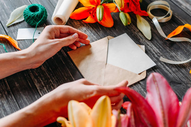 istock High Angle View Of Woman With Envelope Amidst Flowers On Table 1135740046