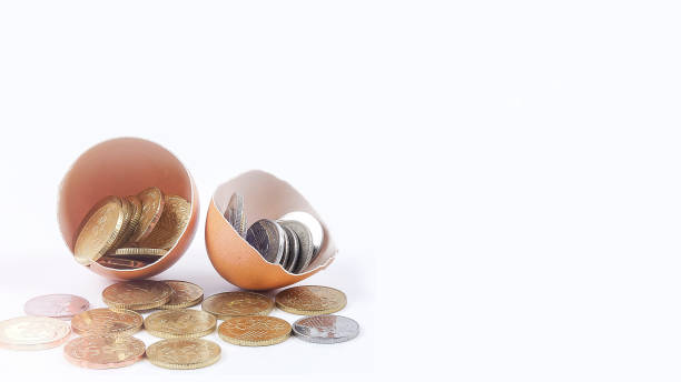 istock Close-Up Of Coins In Broken Eggshell Against White Background 1135741637