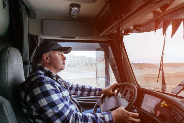 ビッグモダントラックのキャビンでドライバー - flatbed truck truck truck driver heavy ストックフォトと画像