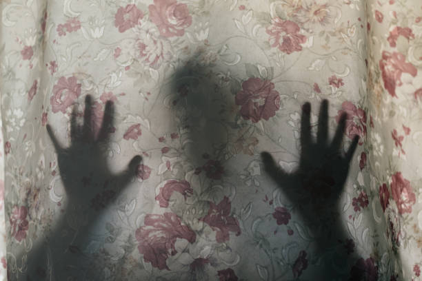 istock Shadow Of Person Hands On Curtain 1135744256