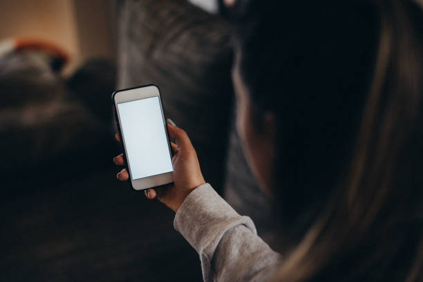 istock Lady's hands holding modern white smartphone with white empty screen 1135744594