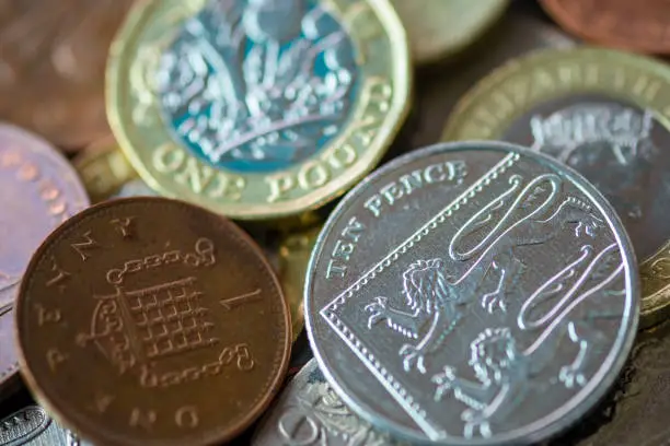 Photo of Close up of fractional currency coins of pound sterling such as Ten pence and one pound . Saving and business concept.