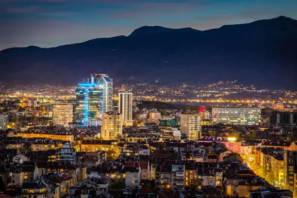 Panoramic high angle view above Southern part of city of Sofia, Bulgaria, Eastern Europe during the blue hour and the downtown night illumination, including: Vitosha mountain and the highest peak of Cherni Vrah as a background. Shot on Canon EOS full frame system with prime lens.