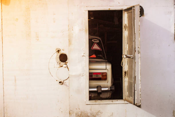 old car behind the open doors of the iron garage