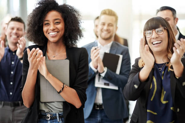 empleados inspirados en todo el año - applauding fotografías e imágenes de stock