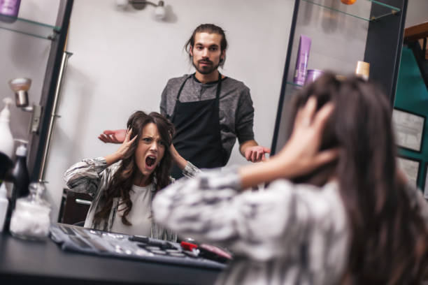 Hairdresser working in his studio Young woman getting new hairstyle at professional hair styling saloon. She is not satisfied with her new hairstyle. angry hairstylist stock pictures, royalty-free photos & images