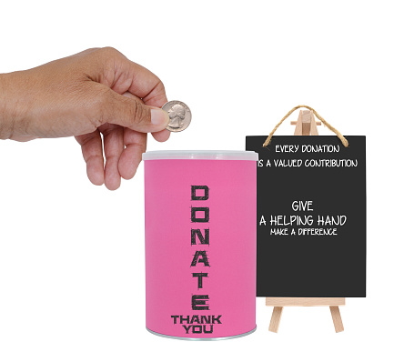 Hand holding quarter over donation container next to blackboard sign (Every donation is a valued contribution)  white background