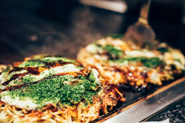 cucina okonomiyaki nel ristorante locale - okonomiyaki foto e immagini stock