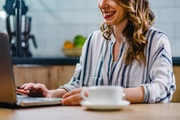 istock Midsection Of Smiling Woman Using Laptop While Sitting On Table 1135756985