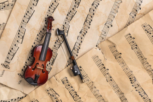istock Miniature violin on vintage paper music notes with copy space 1135757467