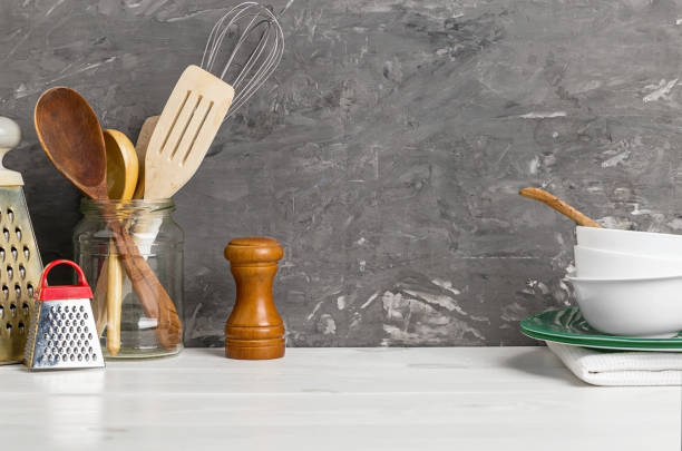 mercadorias dos utensílios da cozinha em uma tabela branca e em um fundo escuro - west old house decor - fotografias e filmes do acervo