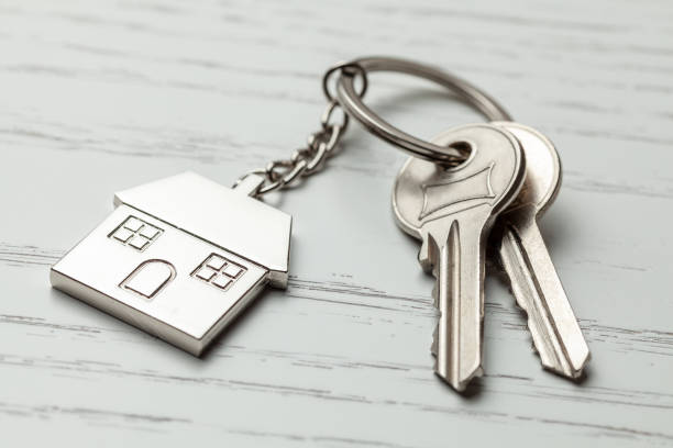istock Keychain house and keys on white wooden background 1135760626