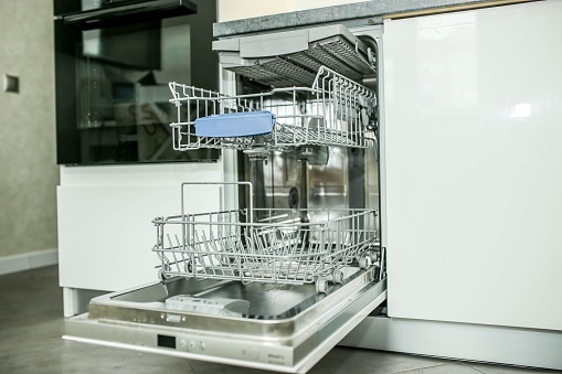 modern dishwasher built into the furniture in the kitchen.