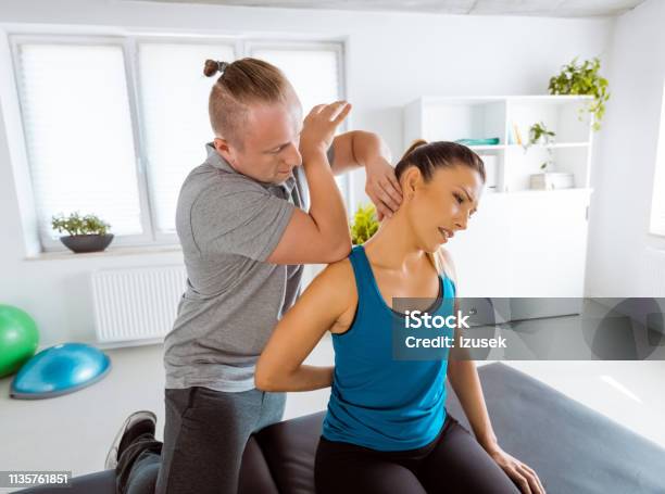 Physiotherapist Massaging Young Woman Stock Photo - Download Image Now - Adult, Adults Only, Alternative Therapy