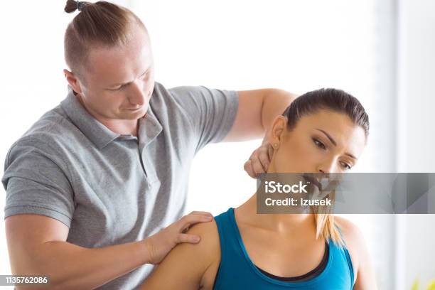 Physiotherapist Stretching Young Womans Neck Stock Photo - Download Image Now - Neckache, Patient, Adult