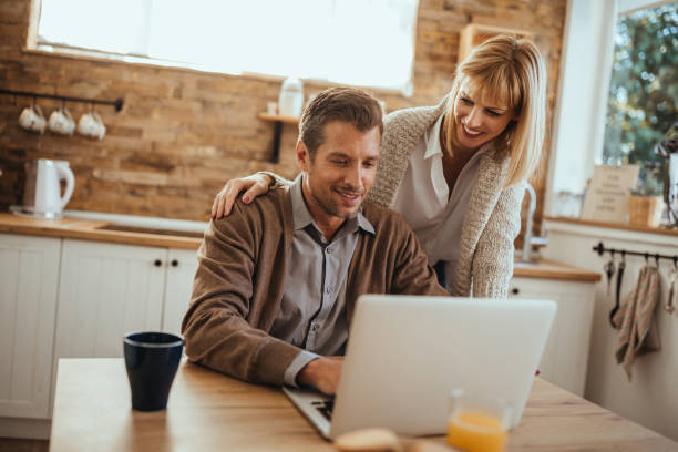 Honey, do you need help? Man working online and his wife is helping him Petrovaradin stock pictures, royalty-free photos & images