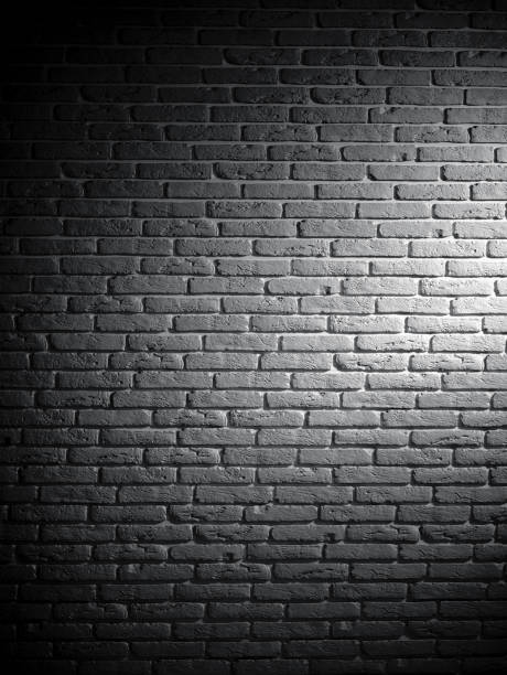 istock Background of black and white brick textured vintage wall with light pattern 1135763376