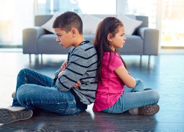 Timeout Full length shot of two naughty young children sitting down on the floor with their backs facing each other at home sibling stock pictures, royalty-free photos & images