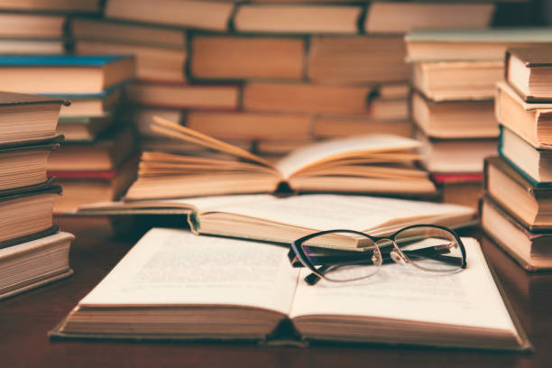 Open book on wood desk in the library room with blurred focus for education background and back to school concept stock photo