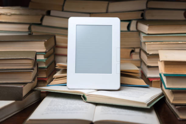 istock Electronic book on background of regular old books 1135763997