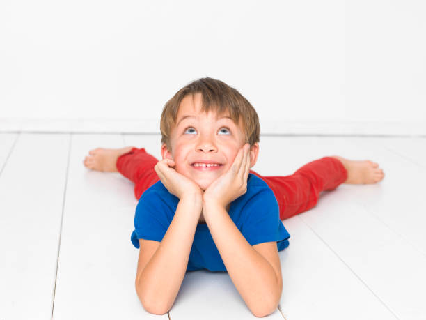 istock cool, six year old boy on white floor 1135765199