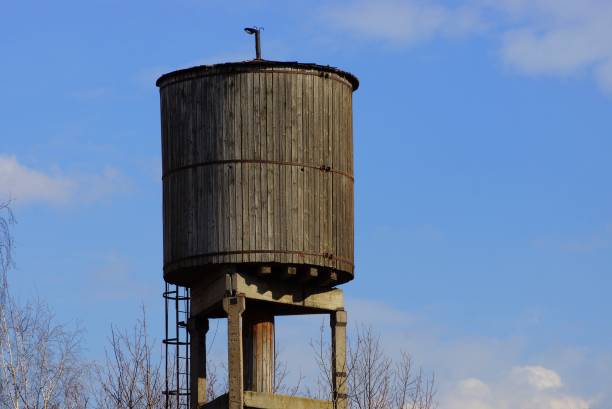 istock old gray wooden water tower against a blue sky and clouds 1135765362