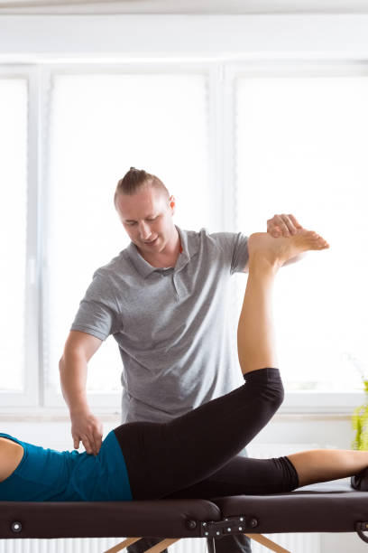 istock Massage therapist stretching young woman's legs 1135765580